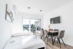 ein Zimmer mit zwei Betten und einem Tisch und Stühlen in der Unterkunft Casa Del Mar in Stara Novalja