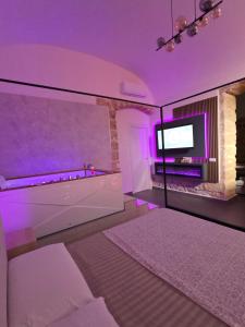 a room with a bed and a tv with purple lighting at Thaleia Suite & Spa in Palermo