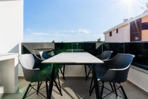 ein Tisch und Stühle auf einem Balkon in der Unterkunft Casa Del Mar in Stara Novalja