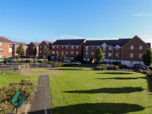 a park in front of a building with a playground at Park View in Banbury