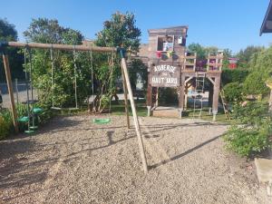 a playground with a swing and a sign at Chez Marie in Drosnay +5 photos