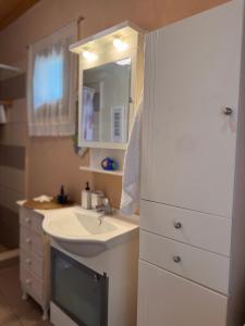 a white bathroom with a sink and a mirror at Sotirias Beach House in Kalamos +83 photos