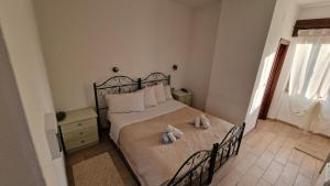 a bedroom with a bed with two stuffed animals on it at Hotel La Vela in Valledoria