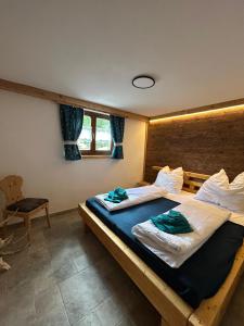a bedroom with two beds and a chair at Linsingerhof in Achenkirch