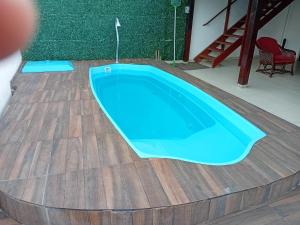 a pool on a wooden deck with a blue swimming pool at Pousada Lagoa Azul in Penha