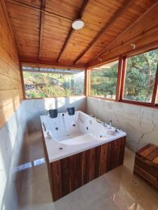 a bathroom with a large tub in a room with windows at Nido y Mirador El Condor Sierra Nevada Guican y El Cocuy in Güicán