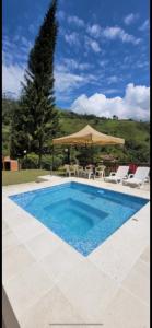 a swimming pool with chairs and an umbrella at La Miel in Barbosa