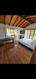 a bedroom with a bed and wooden floors and windows at La Miel in Barbosa