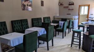 ein Esszimmer mit Tischen und grünen Stühlen in der Unterkunft Jad Hotel Dschang in Dschang
