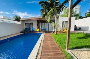 a swimming pool in the backyard of a house at Sunny Side Up - Private 3BR villa with pool in Grand-Baie