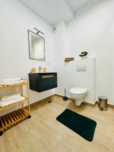 un bagno con un water, un lavandino e uno specchio di Bucuria Studios Mamaia Nord a Mamaia Nord - Năvodari