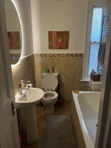 a bathroom with a toilet and a sink and a tub at Wimbledon fortnight in London