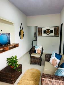 a living room with wicker chairs and a television at casa de veraneio jalapão in São Félix do Tocantins