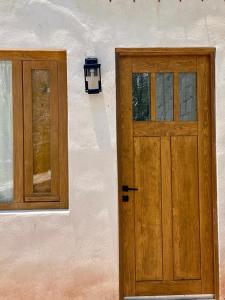 a wooden door and two windows on a building at El Callejón DEPARTAMENTO in Real de Catorce