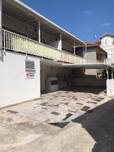 a white building with a balcony and a parking lot at Villa Marica in Trogir