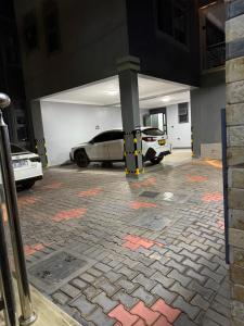 a parking garage with two cars parked in it at Mirembe housing in Nalakonge