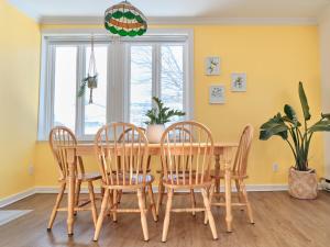 a dining room with a wooden table and chairs at BALCON BLANC - Auberge à Chicoutimi, Saguenay in Saguenay