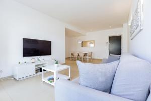 Una sala de estar con un sofá y un televisor. en Cavalo Preto Luxury Beach Apartment by Golden Zenith, en Quarteira