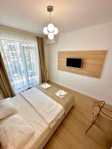 a bedroom with a bed and a flat screen tv at Loft side Premium Apartments in Mamaia +109 photos