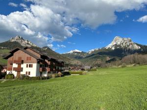 a barn in a field with mountains in the background at Charmant logement tout confort in Bernex