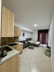 a kitchen and a living room with a couch at Apartament Niko Shengjin 1 in Shëngjin