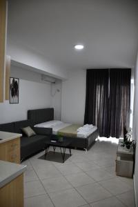 a living room with a couch and a bed at Apartament Niko Shengjin 1 in Shëngjin