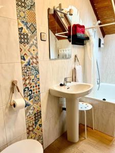 a bathroom with a sink and a toilet and a tub at Apartamento La Buhardilla del Boscache in San Juan de Plan +27 photos
