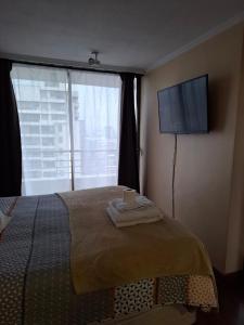サンティアゴにあるSantiago Skyline Suitesのベッドルーム1室(ベッド1台、壁掛け式薄型テレビ付)