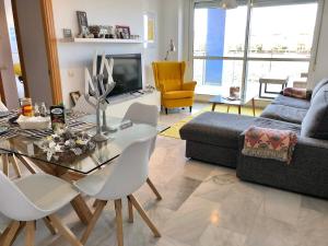 a living room with a glass table and white chairs at Playa Serena 2 habitaciones PRIMERA LINEA DE PLAYA Vista al Mar in Roquetas de Mar