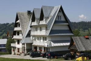 a large building with cars parked in front of it at Pokoje Gościnne Janina in Zakopane