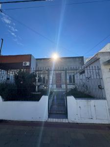 a building with a gate with the sun behind it at Departamento IRIS in Tandil