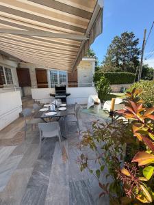 eine Terrasse mit einem Tisch und Stühlen unter Markise in der Unterkunft Villa 45 in Saint-Georges-de-Didonne