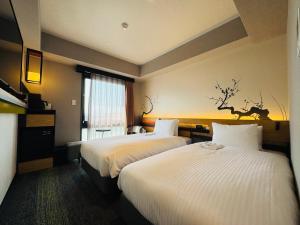 Postel nebo postele na pokoji v ubytování Shizutetsu Hotel Prezio Kyoto Karasumaoike