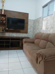 ein Wohnzimmer mit Couch und Flachbildfernseher in der Unterkunft Cantinho da bel in Maragogi