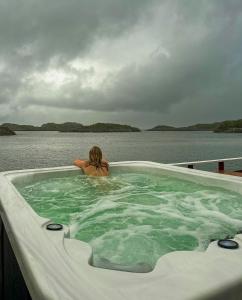 a woman sitting in a hot tub on a boat at Henningsvær Rorbuer in Henningsvær
