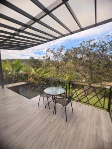 a patio with a table and chairs on a balcony at Luxe Glamping in Moniquirá