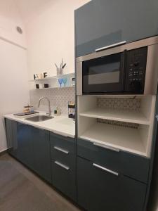 a kitchen with a microwave and a sink at Thaleia Suite & Spa in Palermo