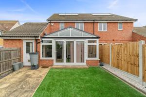 a extension to a house with a lawn at 3 Bed - Sleeps 7 - Hot-Tub - Free Parking in Hornchurch +5 photos