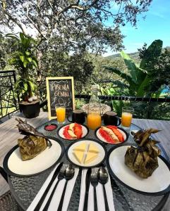 a table with plates of food and drinks on it at Luxe Glamping in Moniquirá