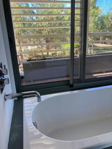 a bathroom with a white sink and a window at Casa Do Mar - Sea View Beach House - Troia Comporta in Troia +39 photos