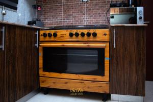a wooden oven in a kitchen with a brick wall at iSoZo Luxury Stays in Ikeja