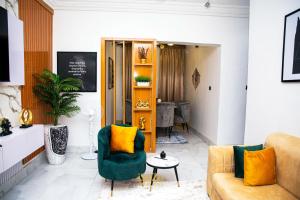 a living room with a green couch and yellow pillows at iSoZo Luxury Stays in Ikeja