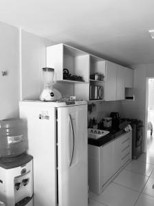 a kitchen with a white refrigerator and a stove at Apartamento térreo no Morro Branco Marina II in Beberibe