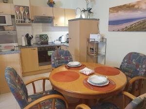 a small kitchen with a wooden table and chairs at Lovely Souterrain Apartment in Solingen