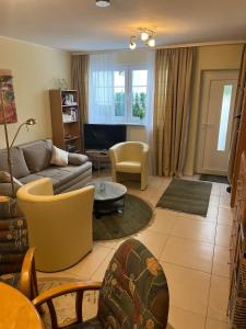 a living room with a couch and a table at Lovely Souterrain Apartment in Solingen