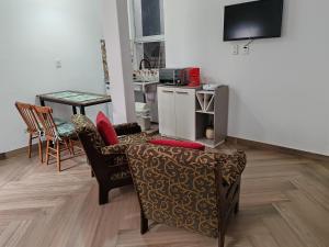 Una sala de estar con un sofá y sillas y una mesa. en Lapacho Roga, en Asunción