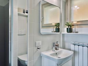 a white bathroom with a sink and a mirror at Tonarino Iseo in Parzanica +17 photos