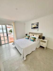 a white bedroom with a bed and a window at CASA TINA piscina privada in Candelaria +17 photos