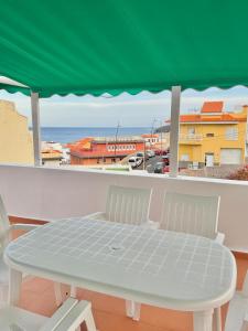 a table and chairs on a balcony with a view of the ocean at CASA TINA piscina privada in Candelaria