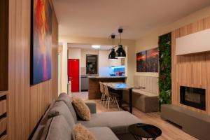 a living room with a couch and a table at MAROVA LUXURY APARTAMENT Caraiman VIEW in Buşteni